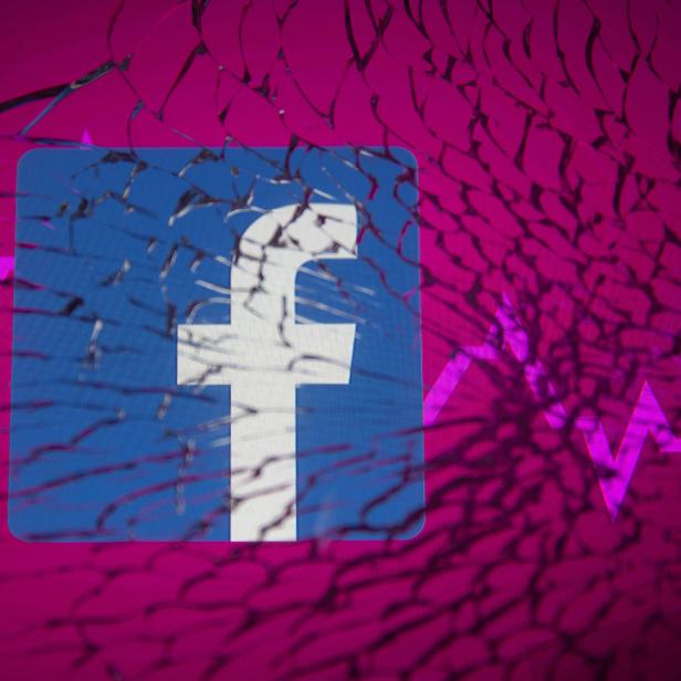 Facebook logo and stock graph are displayed through broken glass in this illustration
