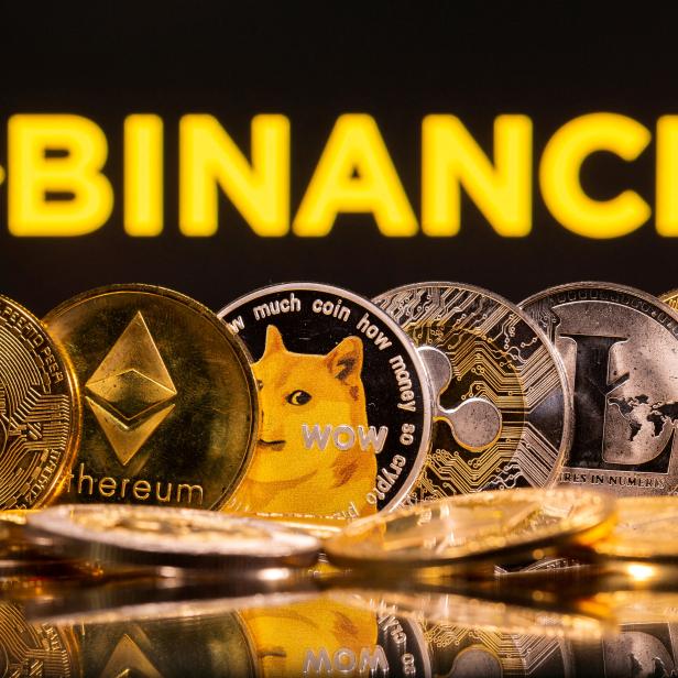 FILE PHOTO: Representations of cryptocurrencies Bitcoin, Ethereum, DogeCoin, Ripple, and Litecoin are seen in front of a displayed Binance logo