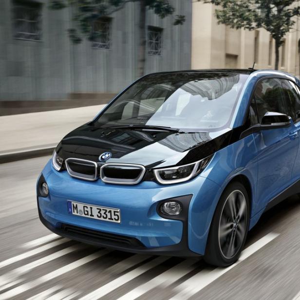 Ein blauer BMW i3 fährt auf einer städtischen Straße.