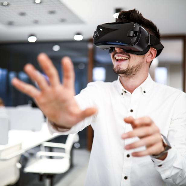 Young Business Man Using VR Glasses Technology At Office