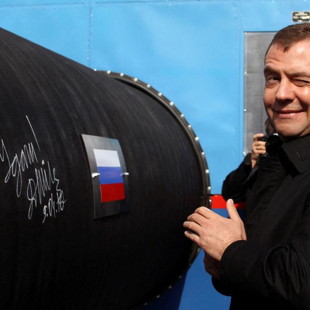 FILE PHOTO: Russian President Medvedev gestures after writing 'Good Luck!' on a pipe of the Nord Stream pipeline near Russian town of Vyborg