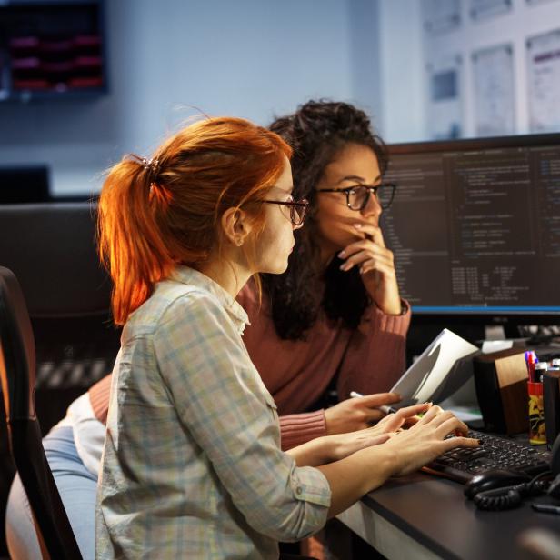 Two female programmers working on new project.They working late at night at the office.