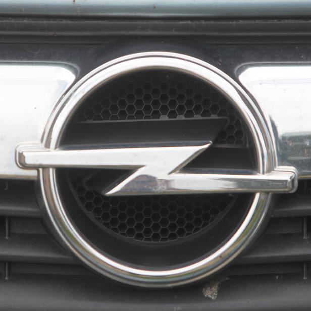 Das Opel-Logo auf dem Kühlergrill eines Autos.