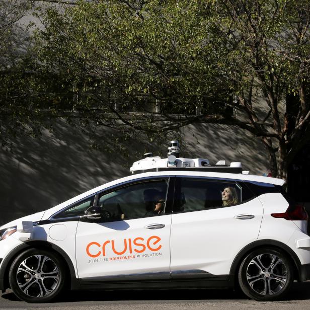 FILE PHOTO: A woman smiles in the back seat of a self-driving Chevy Bolt EV car during a media event by Cruise, GMs autonomous car unit,  in San Francisco