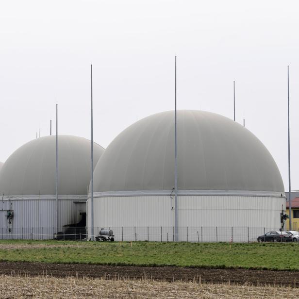 Mehrere Biogasanlagen mit ihren charakteristischen Kuppeln in einer ländlichen Umgebung.