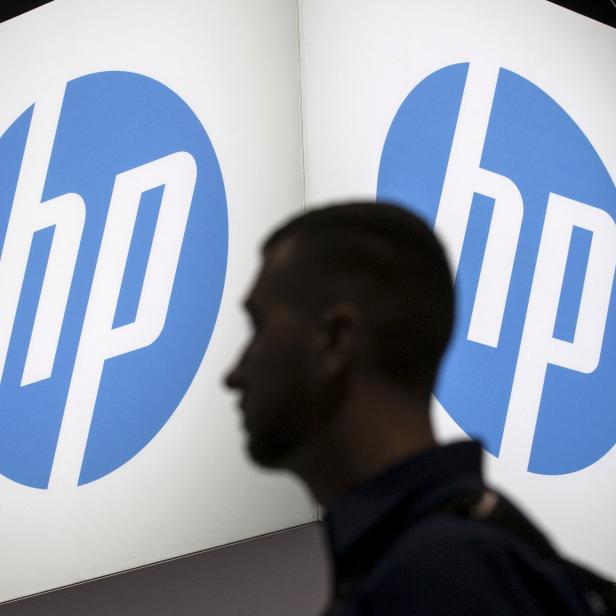 FILE PHOTO: An attendee at the Microsoft Ignite technology conference walks past the Hewlett-Packard (HP) logo in Chicago