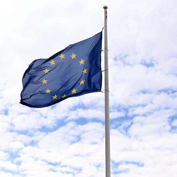 Die Europaflagge weht vor einem Himmel mit weißen Wolken.