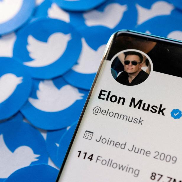 FILE PHOTO: Illustration shows Elon Musk's Twitter profile on smartphone and printed Twitter logos