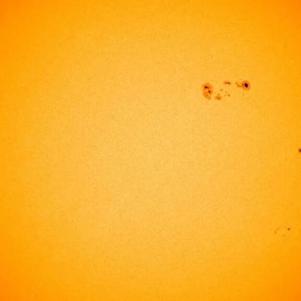 Die Sonne mit mehreren Sonnenflecken vor einem schwarzen Hintergrund.