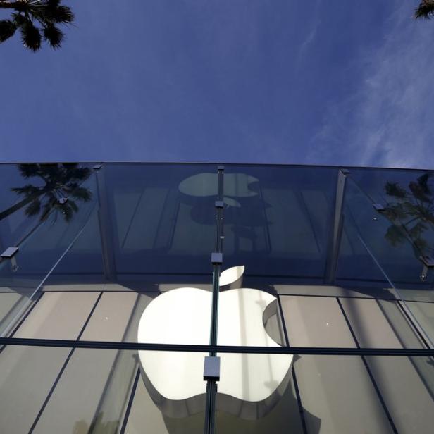Das Apple-Logo ist an einem sonnigen Tag an einem Glasgebäude angebracht.