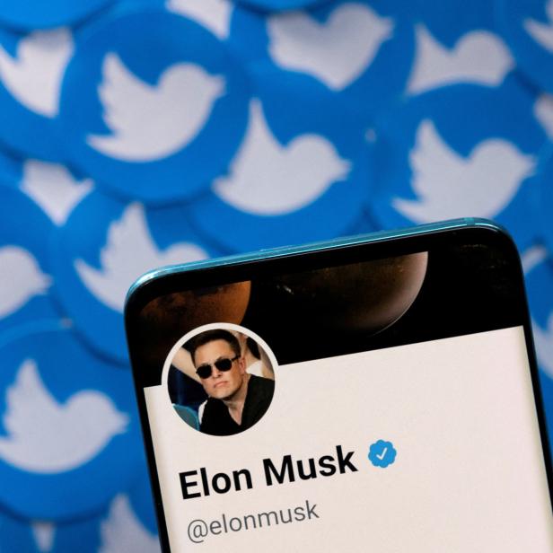 FILE PHOTO: Illustration shows Elon Musk's Twitter profile on smartphone and printed Twitter logos