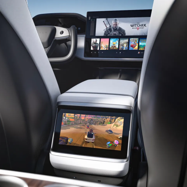 Blick zwischen den Rücksitzen eines Teslas auf zwei Displays mit Spielen drauf