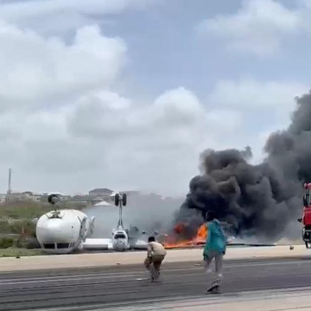 Smoke billows from a plane that flipped over after a crash landing, in Mogadishu