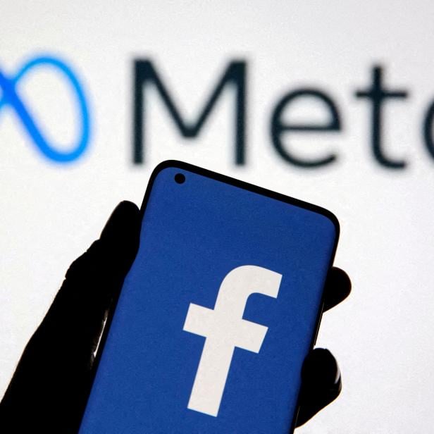 FILE PHOTO: A smartphone with Facebook's logo is seen in front of displayed Facebook's new rebrand logo Meta in this illustration