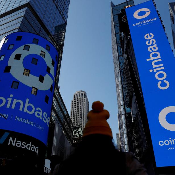 FILE PHOTO: The logo for Coinbase Global Inc is displayed on the Nasdaq MarketSite jumbotron and others at Times Square in New York