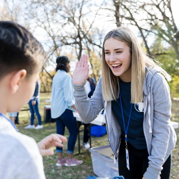 Community outreach volunteer coordinator greets young volunteer