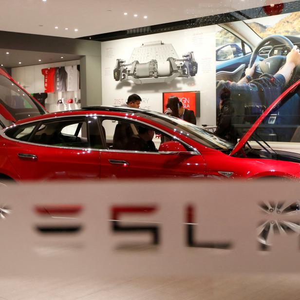 FILE PHOTO: A man looks around Tesla Motors' Model S P85 at its showroom in Beijing