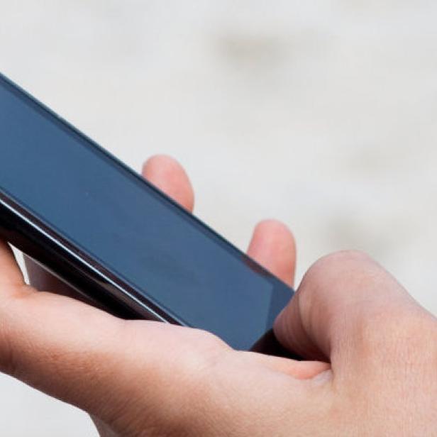 Eine Hand hält ein schwarzes Samsung-Smartphone.