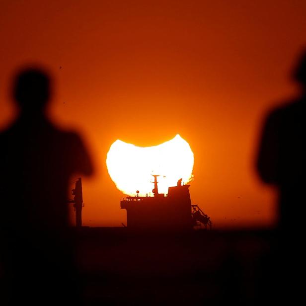 A partial solar eclipse is pictured during sunset in Vina del Mar