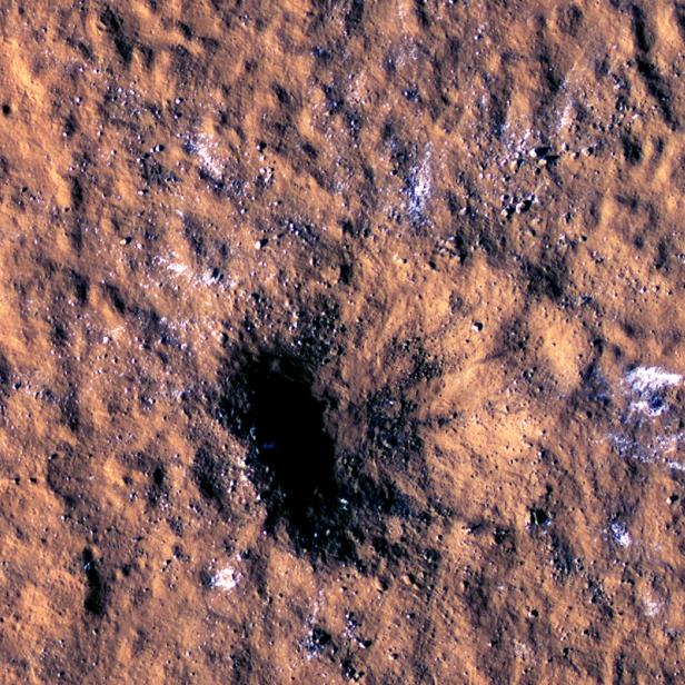 Durch Meteoritentreffer verursachter Krater am Mars, neben dem Eisbrocken zu sehen sind