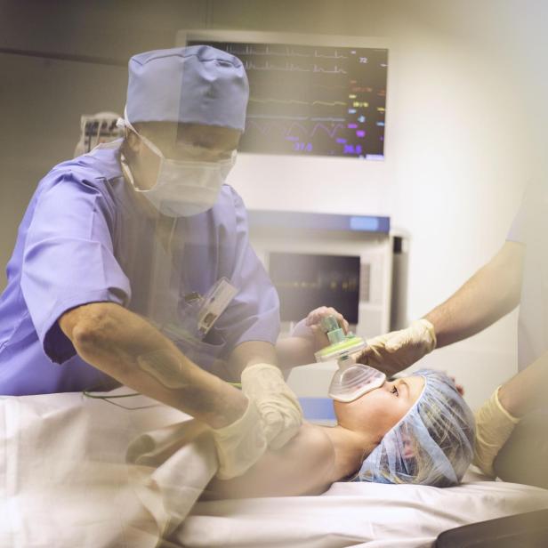 Child with oxygen mask in operating room