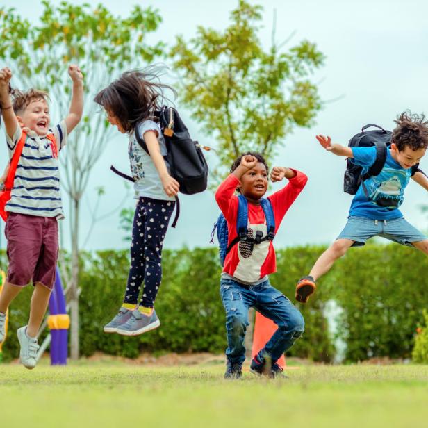 Wilde Kinder mit ADHS springen im Gras herum