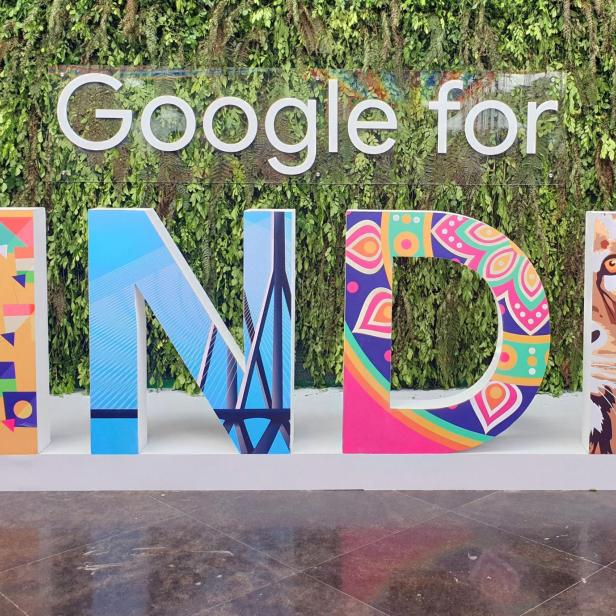 FILE PHOTO: A man walks past the sign of "Google for India", the company's annual technology event in New Delhi