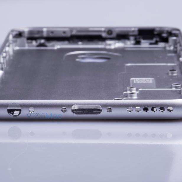 Das leere, silberne Gehäuse eines Smartphones liegt auf einer glänzenden Oberfläche.