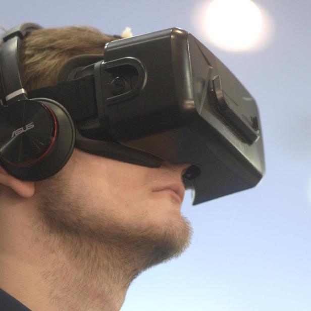 Ein Mann trägt ein VR-Headset und Kopfhörer.