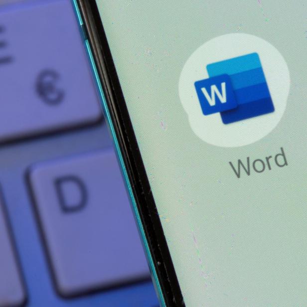 Microsoft Word app is seen on the smartphone placed on the keyboard in this illustration taken