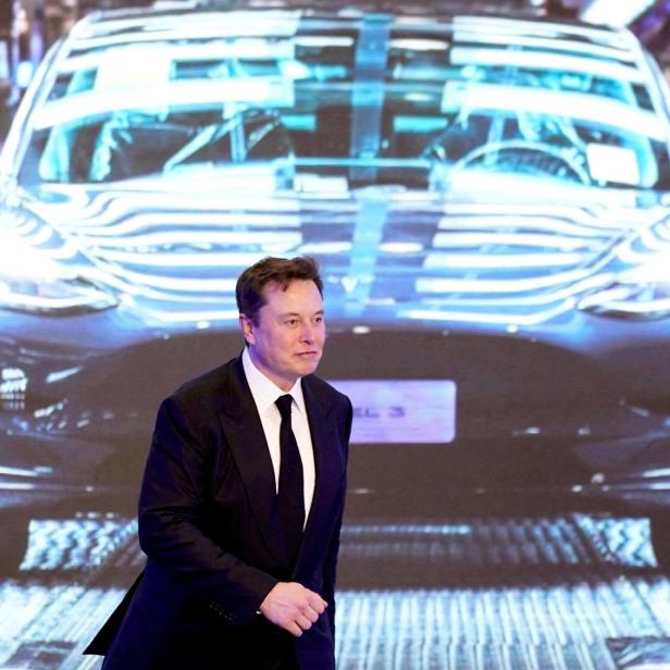 FILE PHOTO: Tesla Inc CEO Elon Musk walks next to a screen showing an image of Tesla Model 3 car during an opening ceremony for Tesla China-made Model Y program in Shanghai