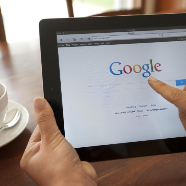 Female hand holding an ipad showing Google.