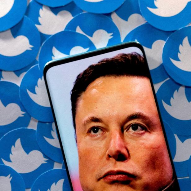 FILE PHOTO: Illustration shows Elon Musk image on smartphone and printed Twitter logos