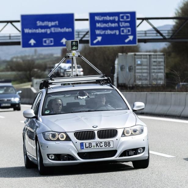 Ein BMW mit Messinstrumenten auf dem Dach fährt auf der Autobahn Richtung Stuttgart und Nürnberg.