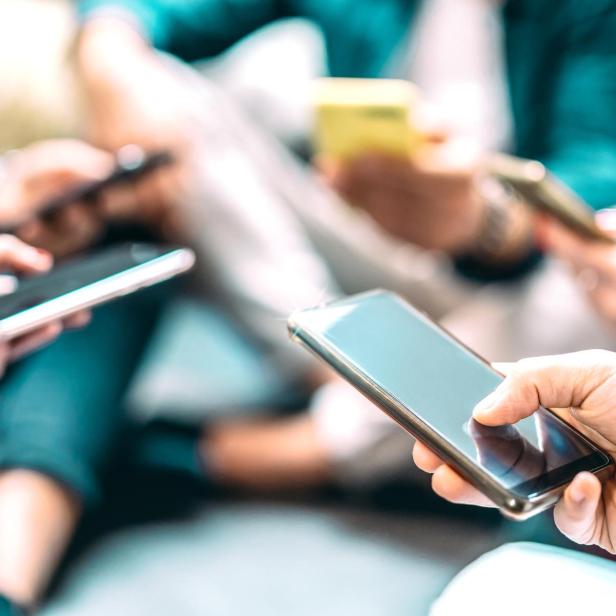 Close up of people using mobile smart phones - Detail of friends sharing photos on social media network with smartphone - Technology concept and cellphone culture with selective focus on right hand