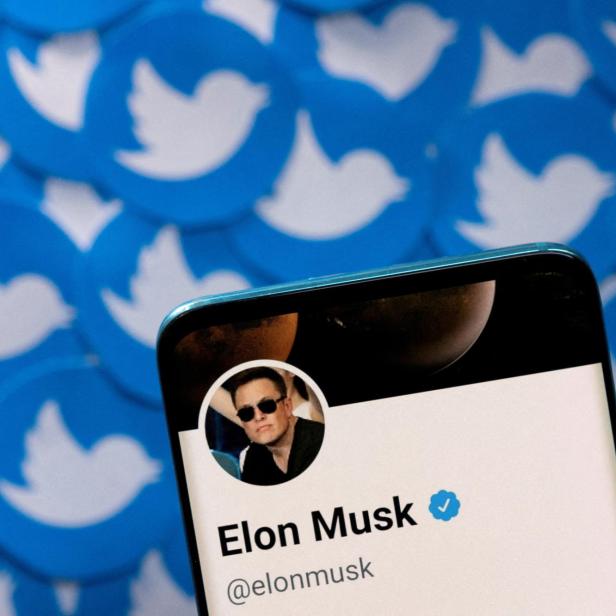 FILE PHOTO: Illustration shows Elon Musk's Twitter profile on smartphone and printed Twitter logos