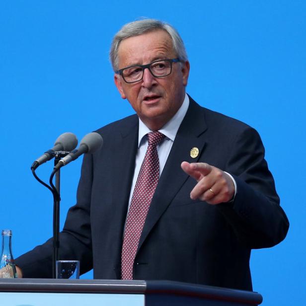 Jean-Claude Juncker spricht vor einem blauen Hintergrund.