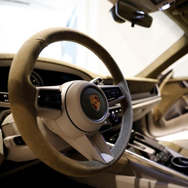 The logo of Porsche is pictured on the steering wheel of a Porsche 911 sports car on display at its dealership during a news conference in Seoul