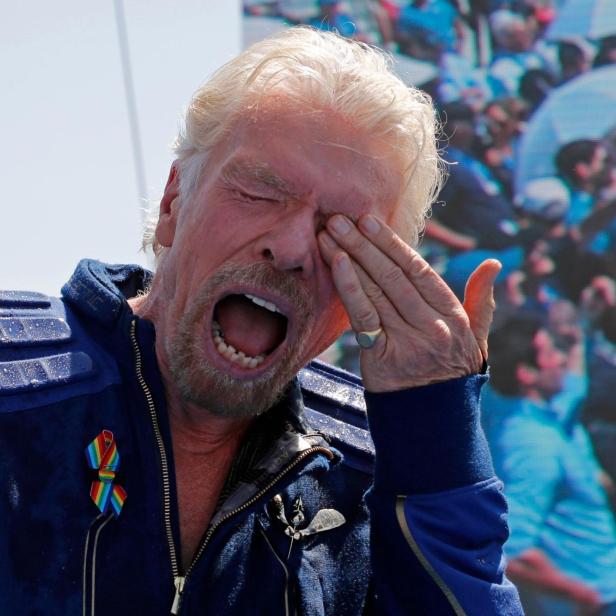 Billionaire entrepreneur Richard Branson reacts from sprayed champagne at Spaceport America