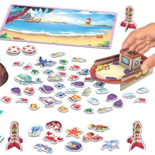 Ein Kind spielt mit einem Brettspiel zum Thema Meer mit einem Bären als Kapitän.