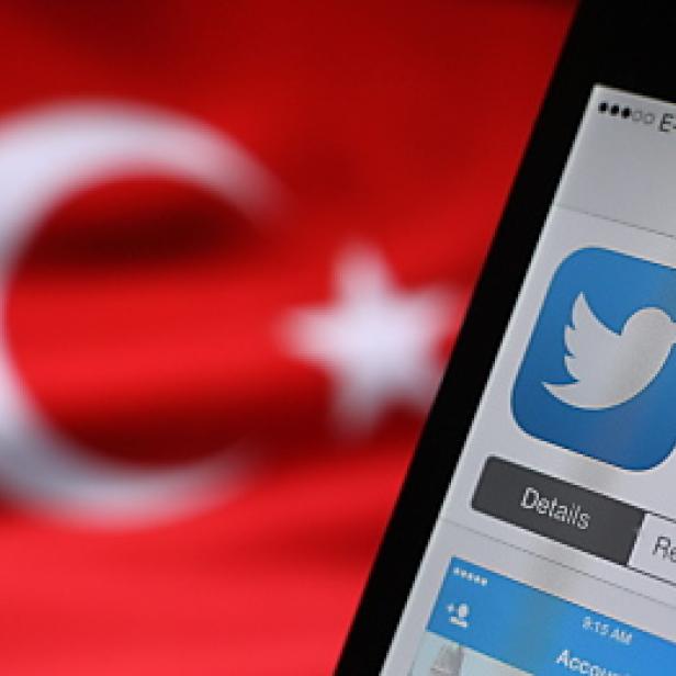 Ein Smartphone zeigt die Twitter-App vor einer türkischen Flagge.