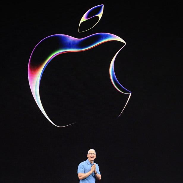 Tim Cook vor Apple-Logo