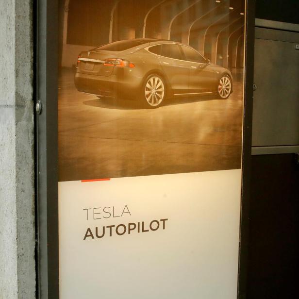 FILE PHOTO: Advertisement promotes Tesla Autopilot at a showroom of U.S. car manufacturer Tesla in Zurich