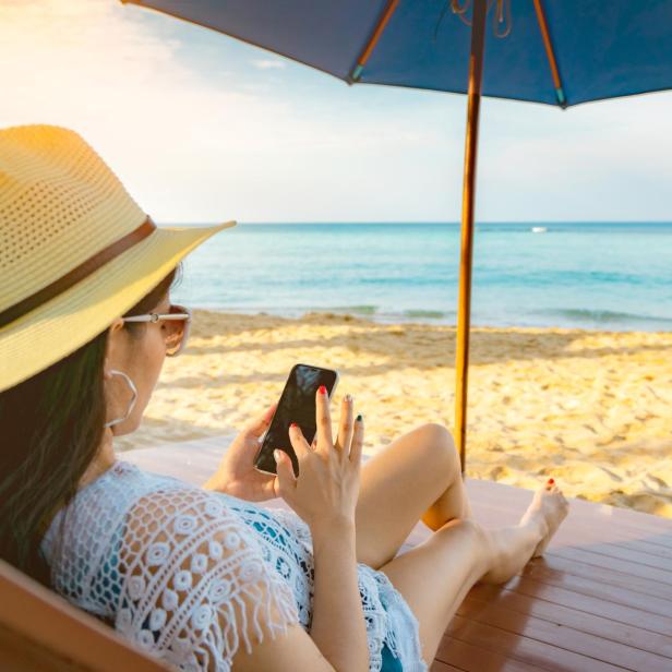 Symbolbild: E-Book-Lesen am Smartphone im Urlaub