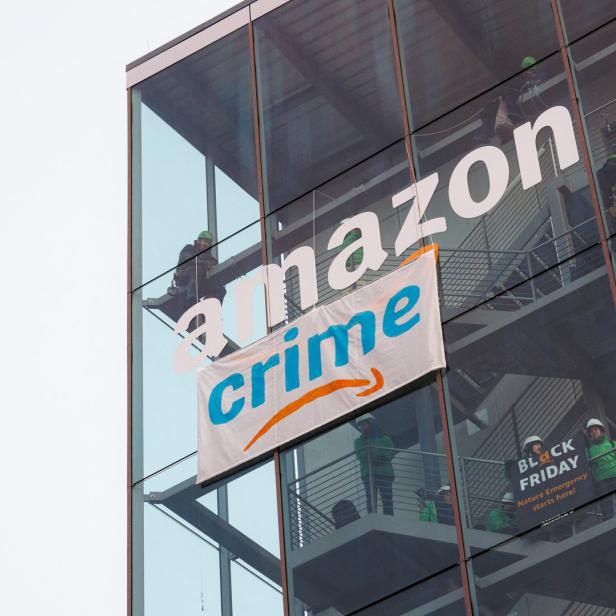 Symbolbild: Greenpeace-Aktivist*innen bringen ein "Crime"-Banner auf einem Amazon-Gebäude an.