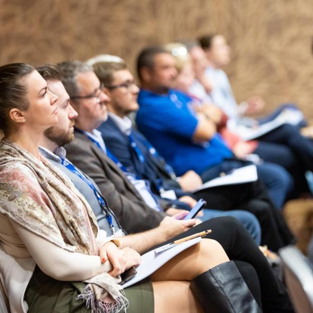 Zuschauer sitzen während einer Präsentation in einem Publikum.