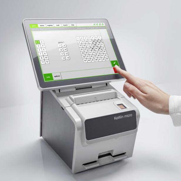 Eine Hand tippt auf ein KeWin Micro-Gerät zur Tippscheinabgabe.