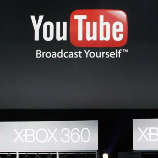 Ein Mann steht auf einer Bühne vor Logos von YouTube und Xbox 360.