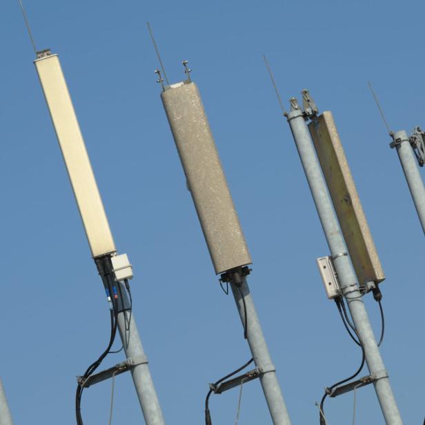 Mehrere Mobilfunkantennen vor blauem Himmel.