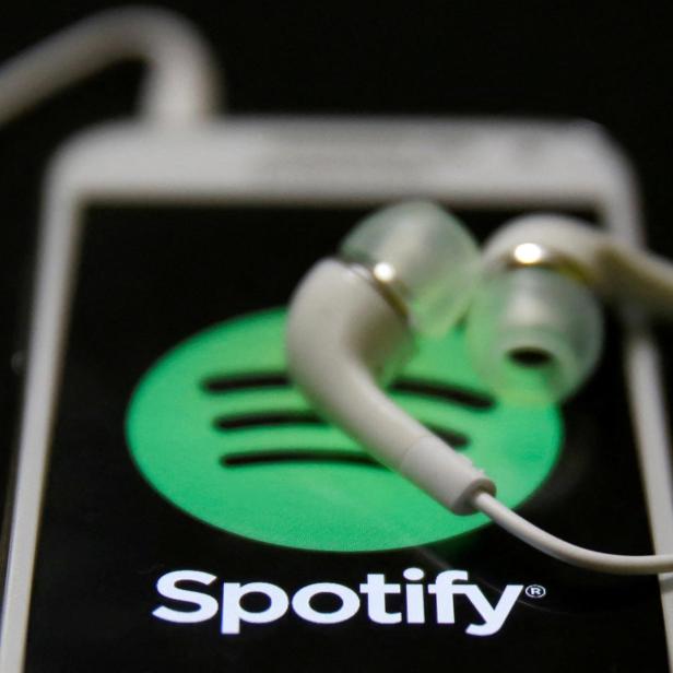 FILE PHOTO: Earphones are seen on top of a smart phone with a Spotify logo on it, in Zenica